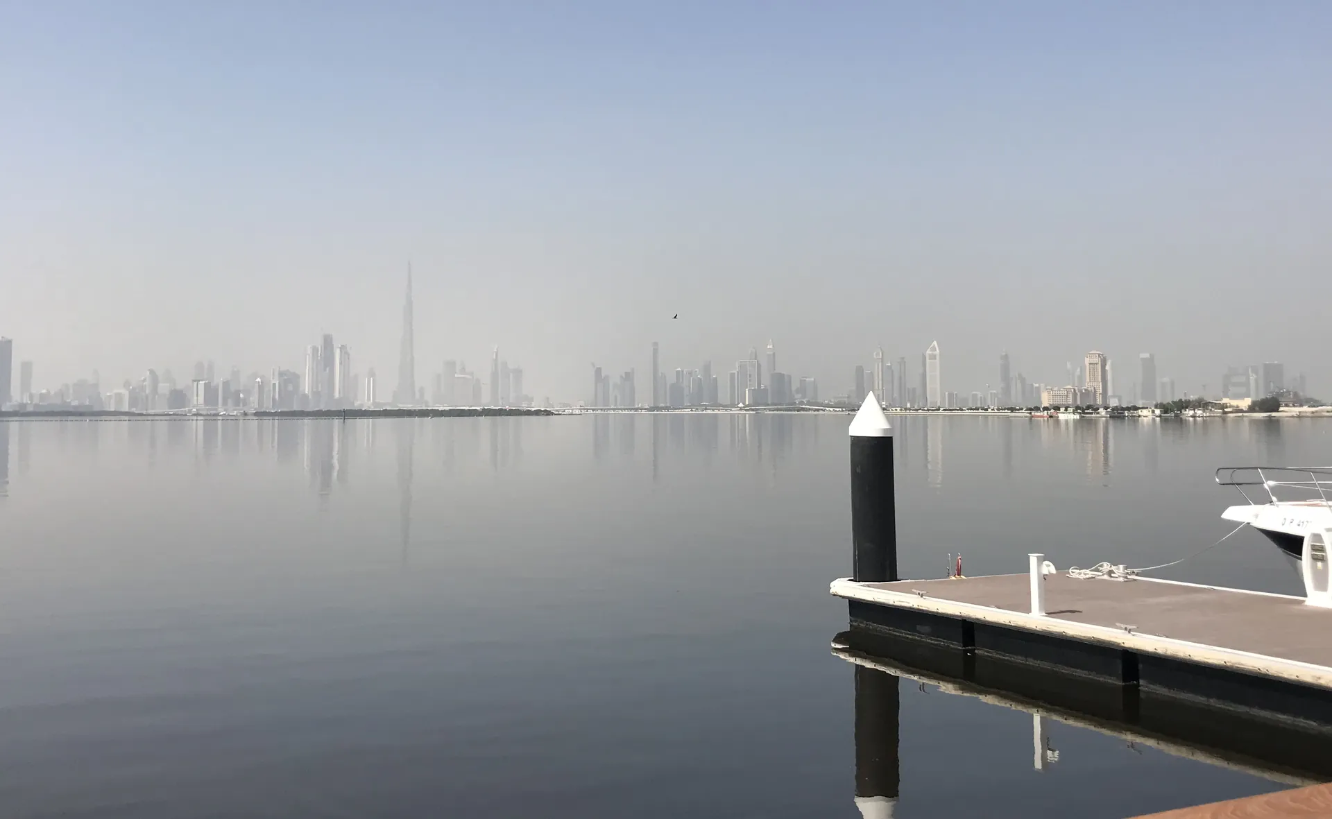 Calm water of the Creek from a Creek Harbour pontoon, Burj Khalifa on the horizon